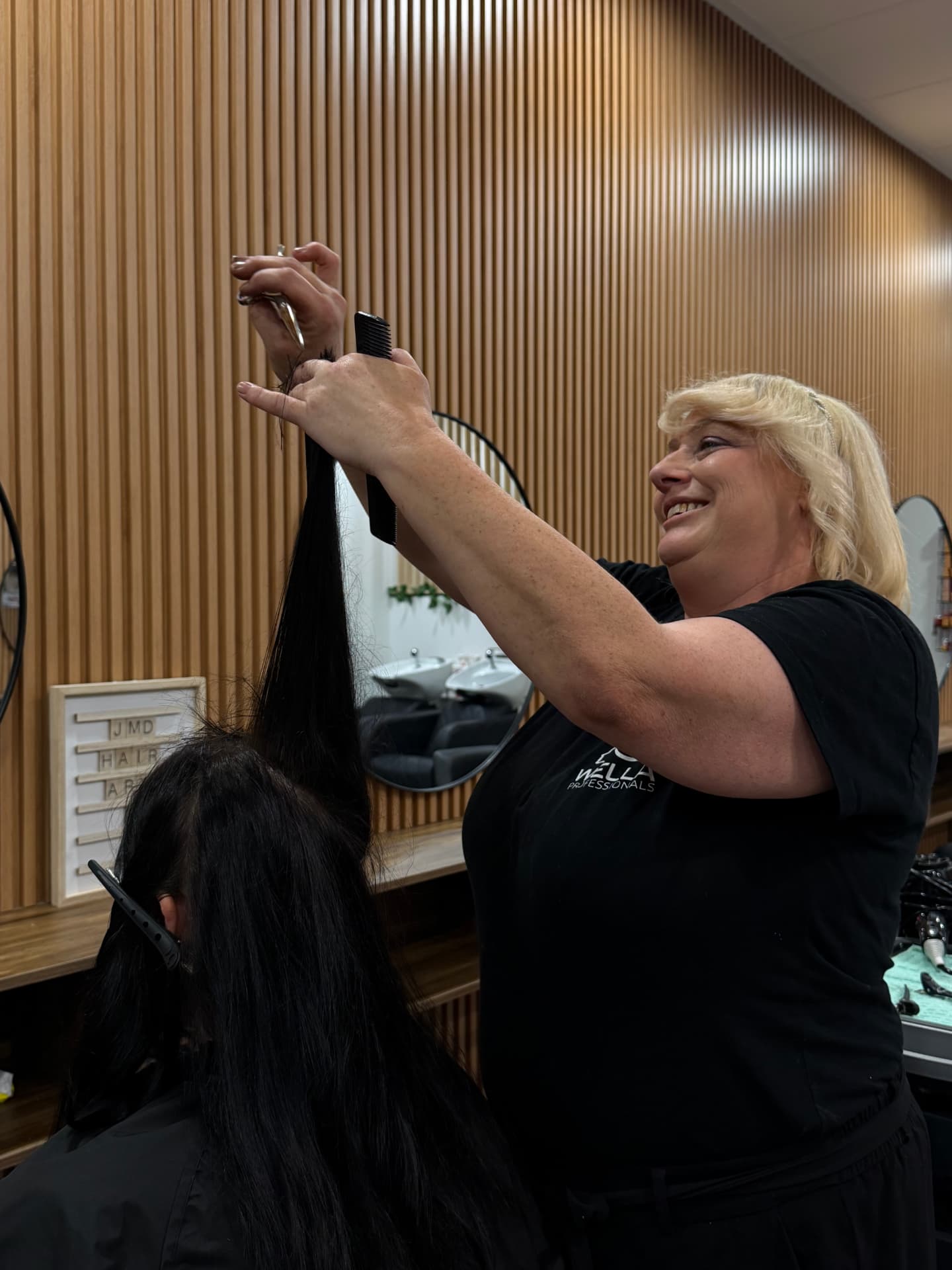 JMD Hair Art stylist sectioning long black hair before a fresh haircut