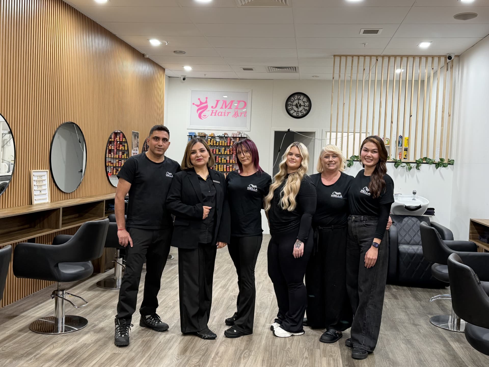 The JMD Hair Art team of stylists standing inside the salon