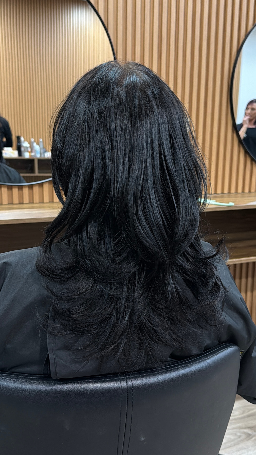 Glossy layered black hair finished at JMD Hair Art