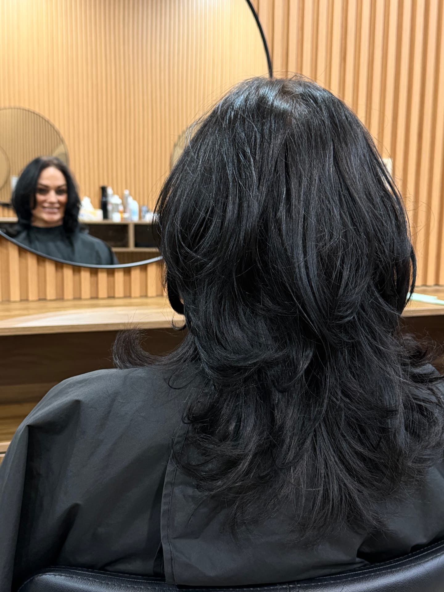Happy client with glossy layered hair at JMD Hair Art